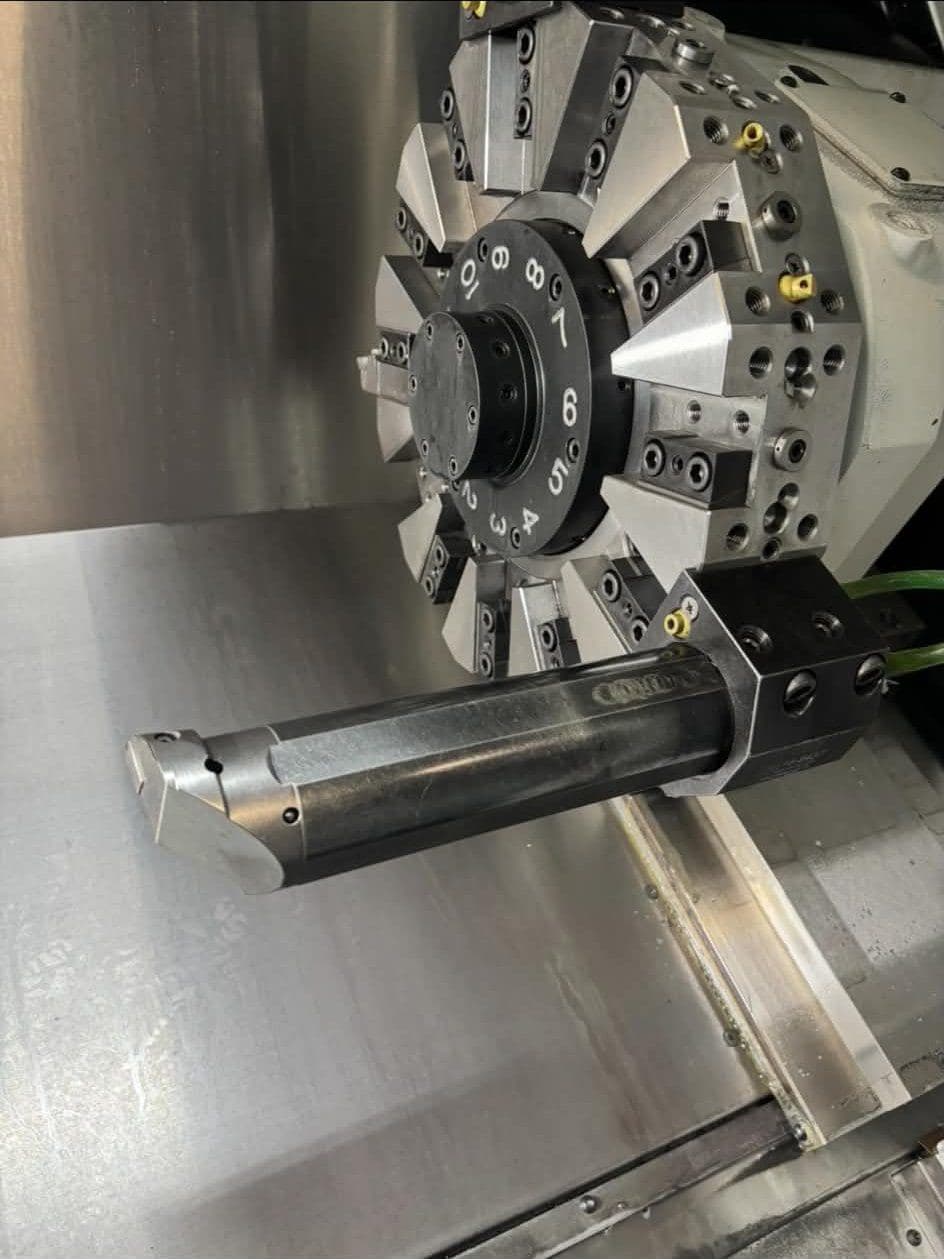 A tool turret loaded with holders and a boring bar inside a CNC lathe.